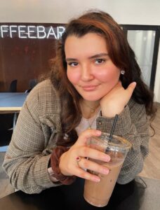 Girl with brown hair holding an ice coffee